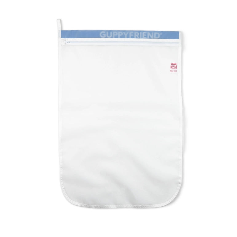 The GUPPYFRIEND Washing Bag-Medium (19.7 in. x 29.1 in.) is a white laundry bag with a blue zipper, designed to minimize fiber shedding and reduce microplastics, featuring a rectangular shape with a rounded bottom edge for efficient cleaning without environmental harm.