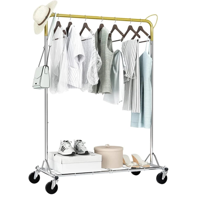 The Above Edge Hanging Garment Rack with Shelf showcases light-colored garments on wooden hangers, accompanied by a white hat and handbag. The lower shelf holds sneakers, a round box, and sandals. This versatile structure is equipped with wheels for easy movement.