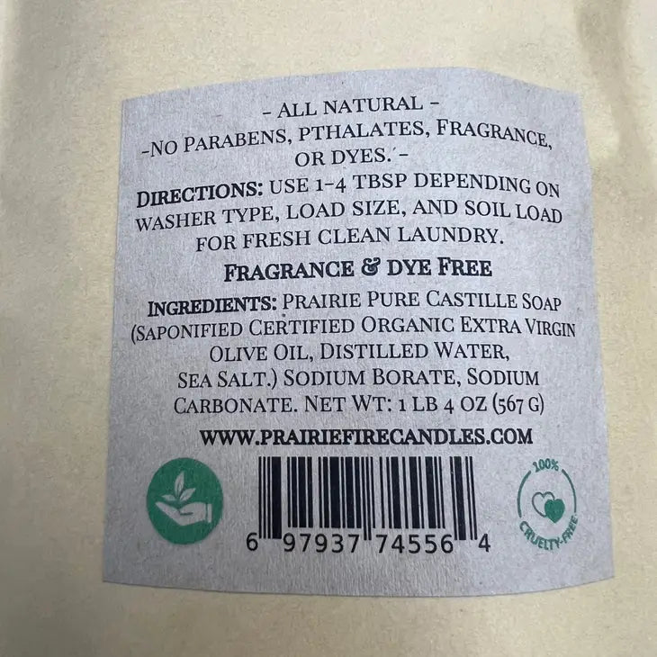 The label of Prairie Fire Candles Prairie Pure Castile Organic Olive Oil Laundry Powder (Fragrance-Free, 1lb 4oz) highlights its all-natural formula ideal for sensitive skin. Free from parabens, phthalates, fragrance, and dyes, it includes usage directions, ingredients, website details, and certification icons.