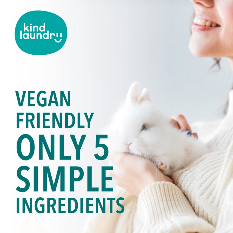 A person gently holds a fluffy white rabbit, smiling. Text reads Kind Laundry: Vegan Stain Remover Bar with 5 Simple Ingredients and Phosphate-Free on a light background.