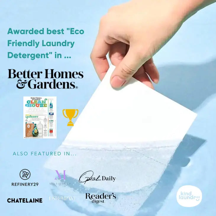 A hand holds a Zero Waste Laundry Detergent Sheet-Fragrance Free-60 Loads by Kind Laundry, awarded Best Eco-Friendly Laundry Detergent by Better Homes & Gardens. Infused with tea seed oil for freshness and endorsed by Refinery29, Oprah Daily, Readers Digest. Water in the background.