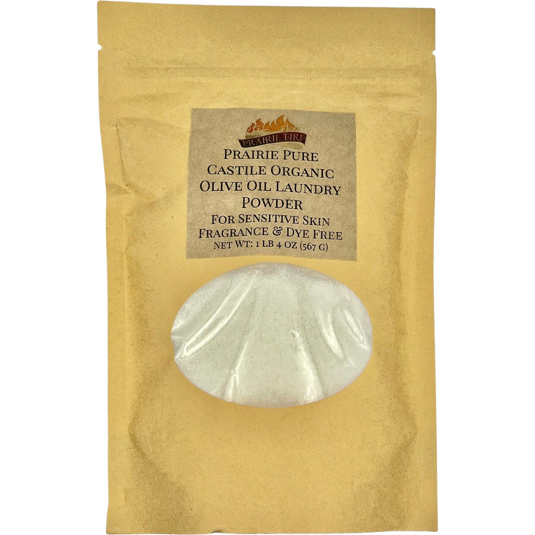 A brown paper bag of Prairie Fire Candles Prairie Pure Castile Organic Olive Oil Laundry Powder for sensitive skin, fragrance and dye-free. Weighing 1 lb 4 oz (56 g), the bag has a clear window to show the powder inside, perfect for delicate skin needs.