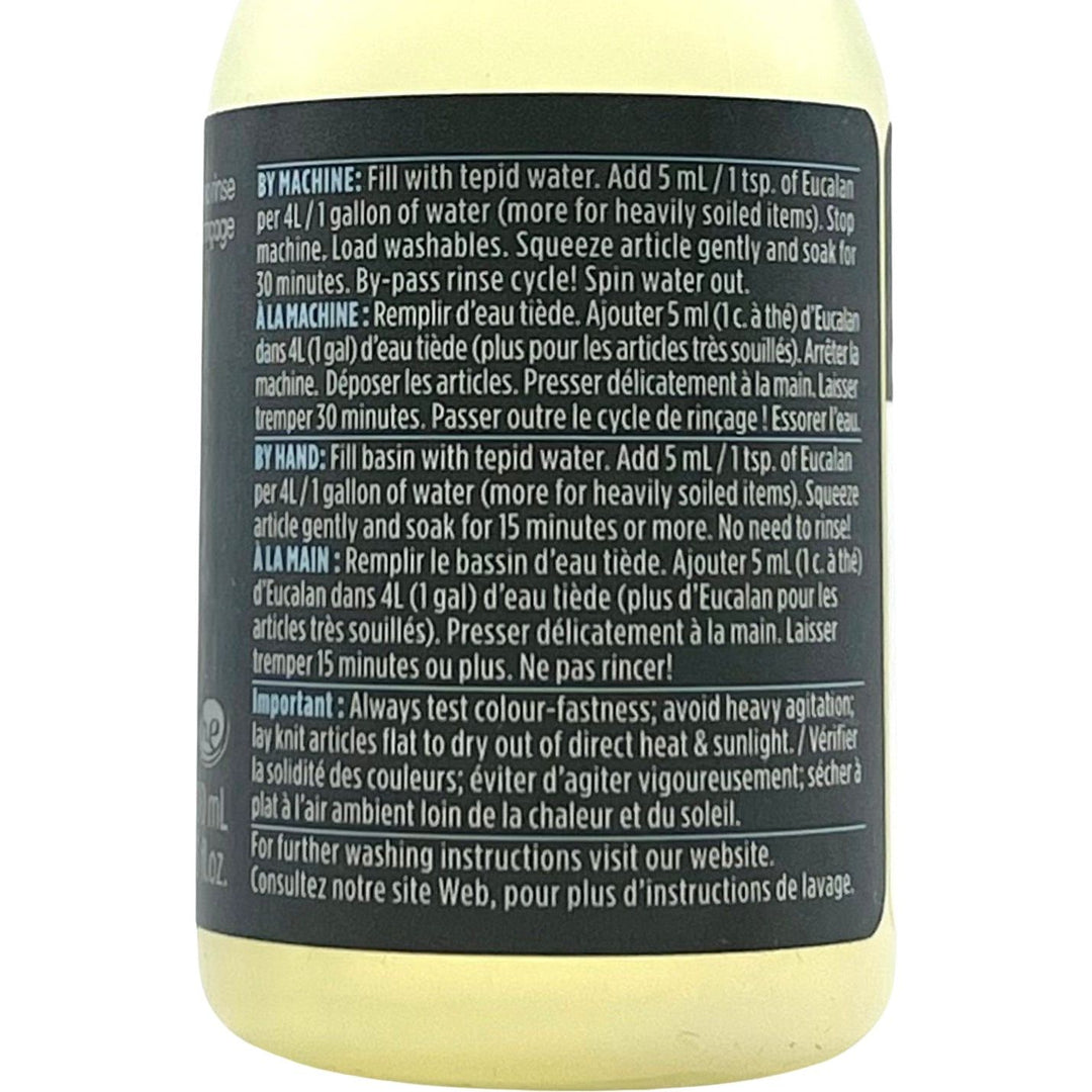 A label on Eucalans Unscented Delicate Wash (100 ml) displays washing instructions in English and French. The formula is eco-friendly, suitable for machine and handwashing. Key notes: test colorfastness, avoid heat, and use the no-rinse wash method.