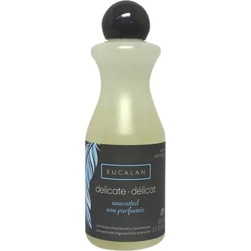 The Unscented Delicate Wash 100 ml (3.3 oz) by Eucalan is ideal for handwashing, featuring a no-rinse, eco-friendly formula. The light bottle has a black cap and dark label with leaf design, and text in English and French.