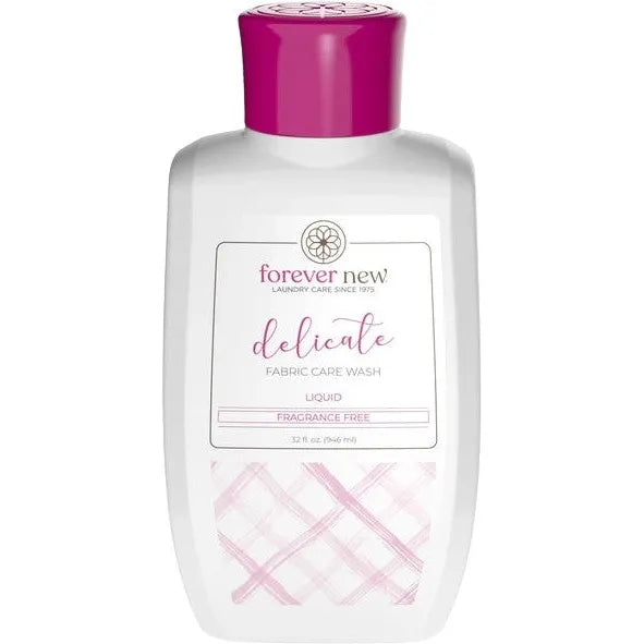 A 32 oz white bottle of Forever New Internationals Delicate Liquid Detergent features a pink cap and plaid-patterned design. The label, Fragrance Free, emphasizes its gentle cleansing for sensitive skin.