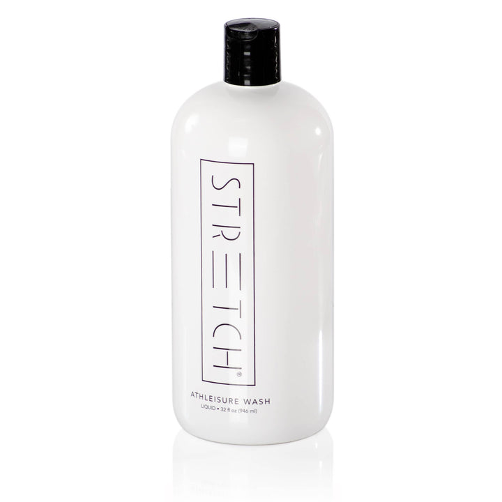 A white bottle of Forever New Internationals STRETCH Liquid Active Wear Detergent features a black cap and vertical label. This 32 oz biodegradable formula effectively eliminates odors, keeping your activewear fresh and clean.